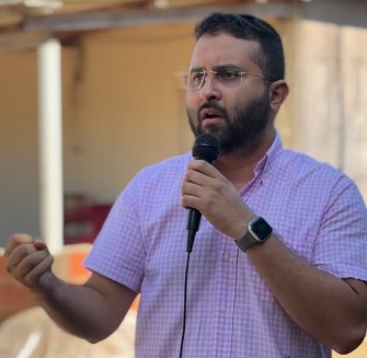 Dr. Junior Nascimento discursando ao microfone em evento comunitário aberto
